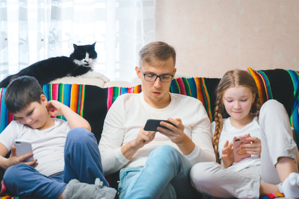 Familia en el sofá con teléfonos